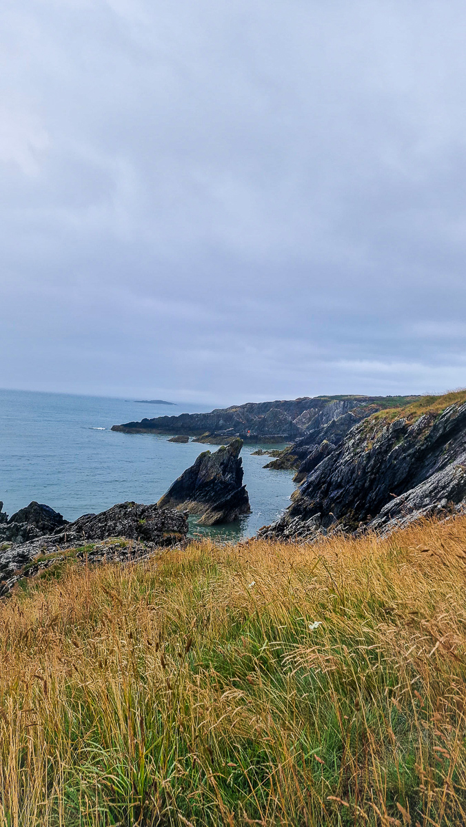 Rugged coastal cliffs landscape photography with sea stacks and dramatic sky by Tony Livins