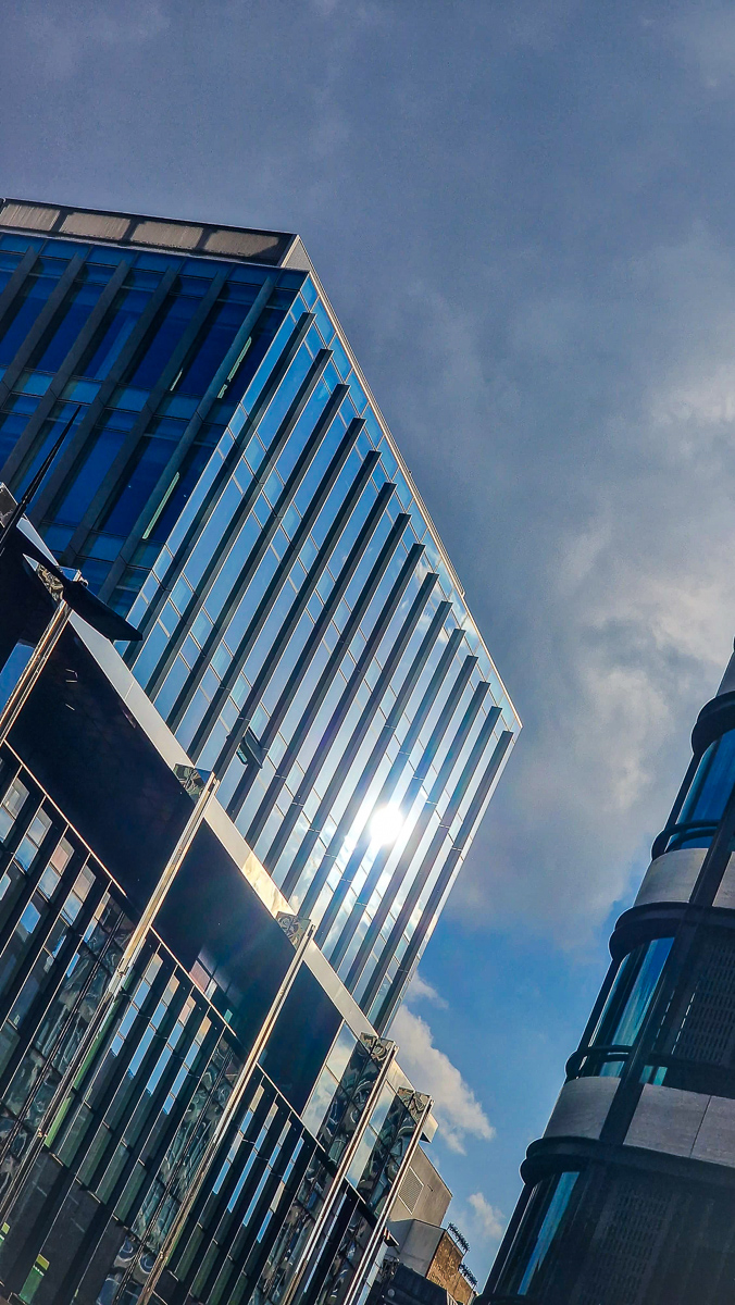 Modern glass tower architecture photography with sunlight reflection by Tony Livins